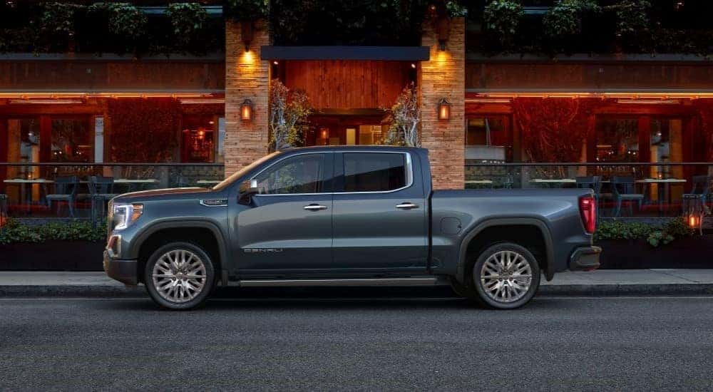 A blue 2019 used GMC Sierra 1500 for sale is shown from the side in front of a restaurant.