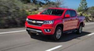 A red 2015 Chevy Colorado is shown from the front at an angle is shown after leaving a dealer that has a used Chevy Colorado for sale.