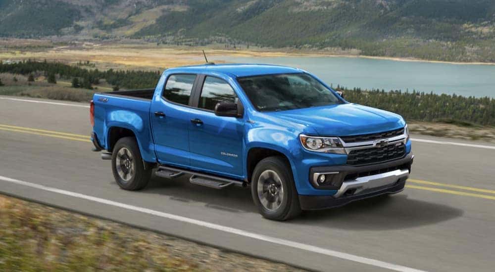A popular used Chevy Colorado for sale, a blue 2022 Chevy Colorado Z71, is shown driving on a highway.
