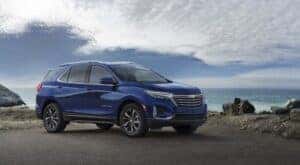 A blue 2022 Chevy Equinox Premier is shown from the side after leaving a Chevy Equinox dealer.