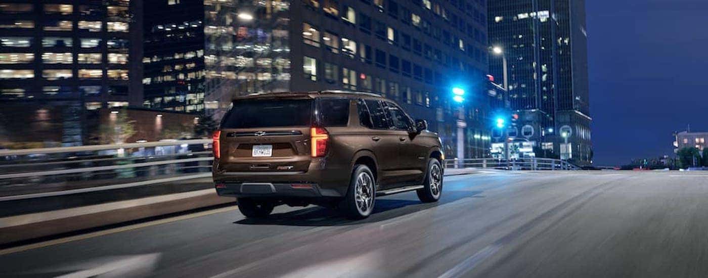 A brown 2022 Chevy Tahoe RST is shown from the rear at an angle after leaving a American Fork Chevy dealer.