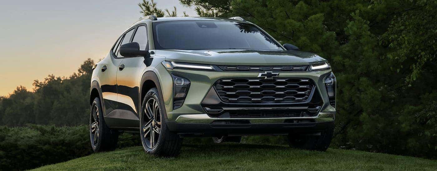 A green 2024 Chevy Trax is shown parked on a grassy area after leaving a Chevy dealer near Midvale.