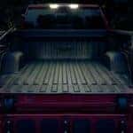 The open tailgate of a red 2024 Chevy Silverado 1500 is shown.