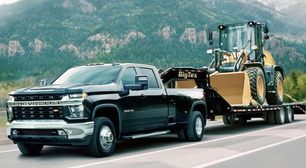 A black 2020 Chevy Silverado 3500HD is shown towing a trailer.