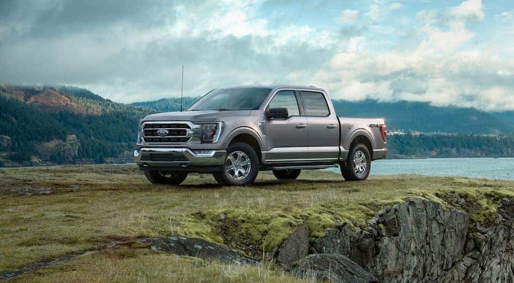 A silver 2021 Ford F-150 is shown parked near a cliff.