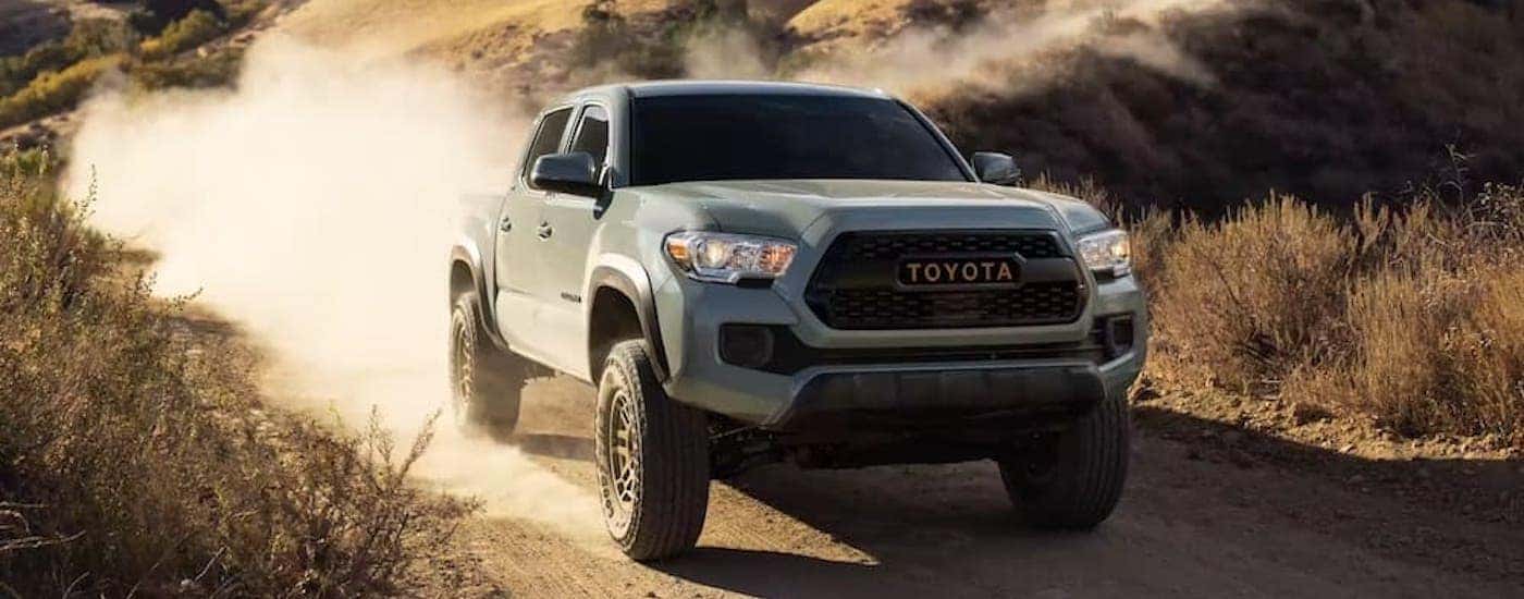 A grey 2022 Toyota Tacoma Trail is shown from the front at an angle after leaving a dealer that has used trucks for sale near Sandy.