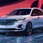 A white 2024 Chevy Equinox Redline Edition is shown driving on a bridge.