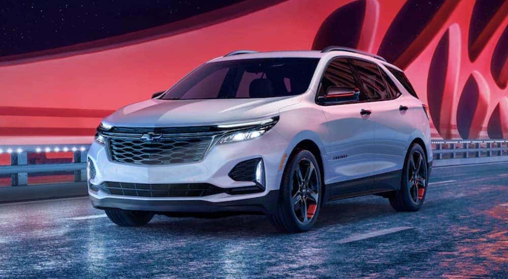 A white 2024 Chevy Equinox Redline Edition is shown driving on a bridge.