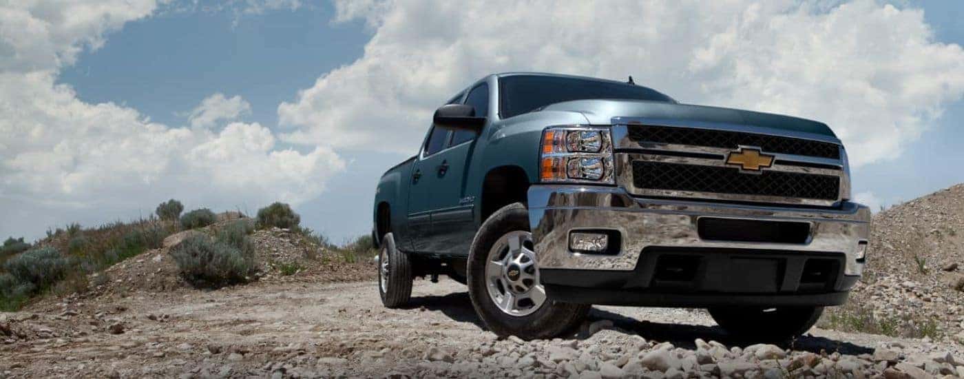 A blue 2012 Chevy Silverado 2500 HD is shown parked off-road.