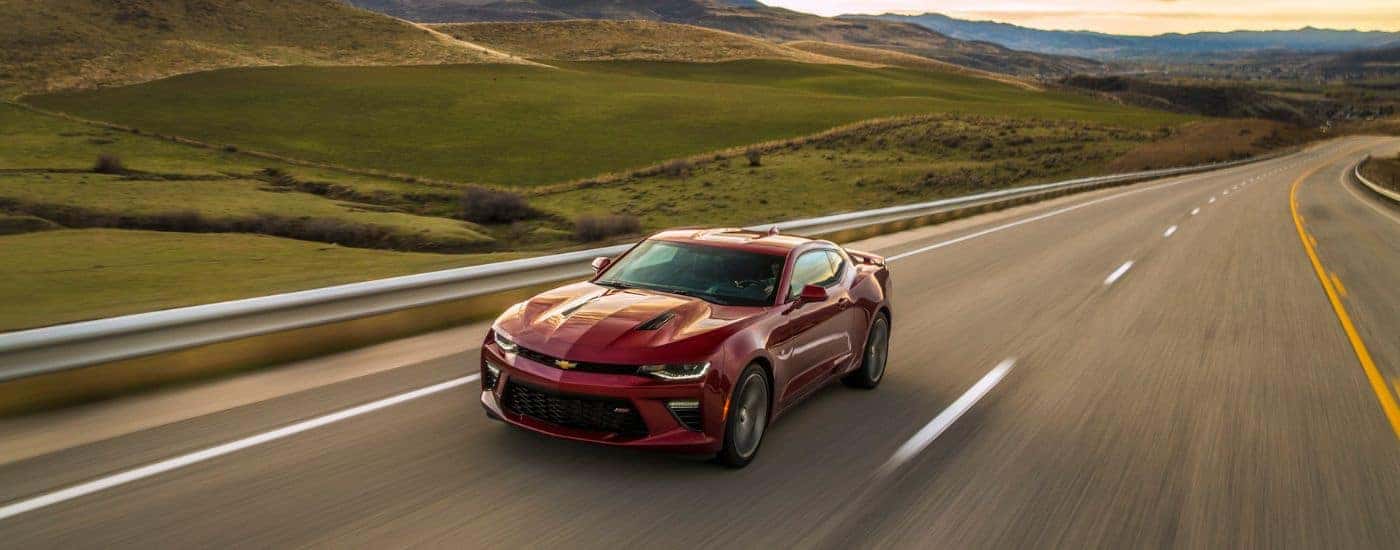 A maroon 2016 Chevy Camaro SS is shown driving on an open road.