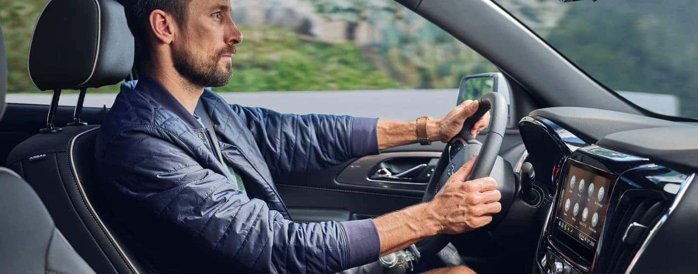 A person is shown driving a 2023 Chevy Traverse.