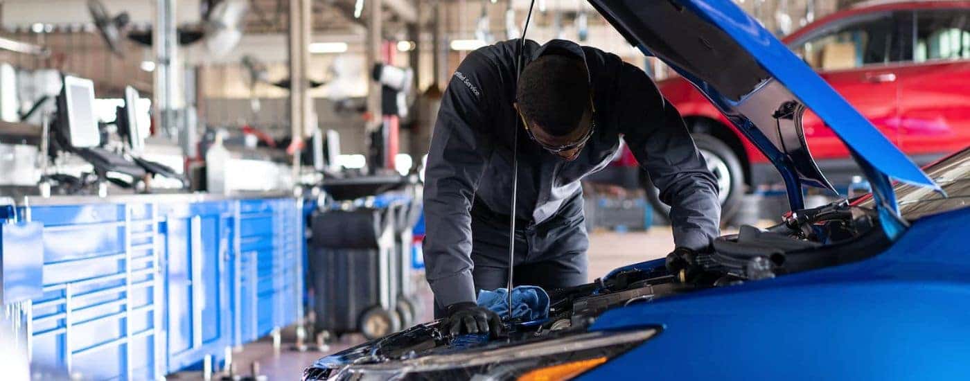 A mechanic is shown working on a vehicle.