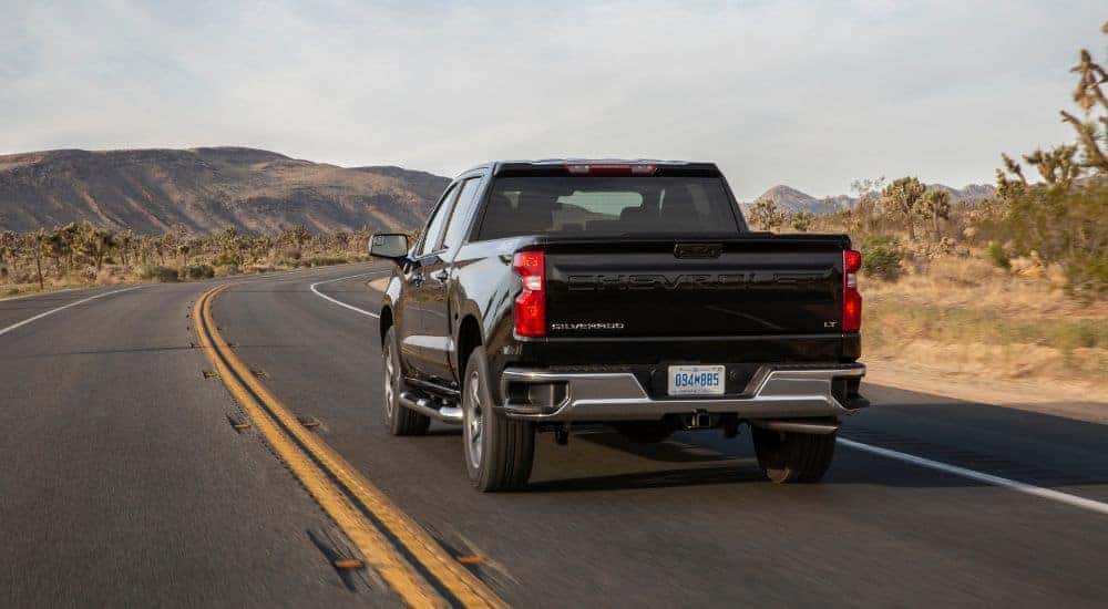 A black 2022 Chevy Silverado 1500 LT is shown driving on a highway.