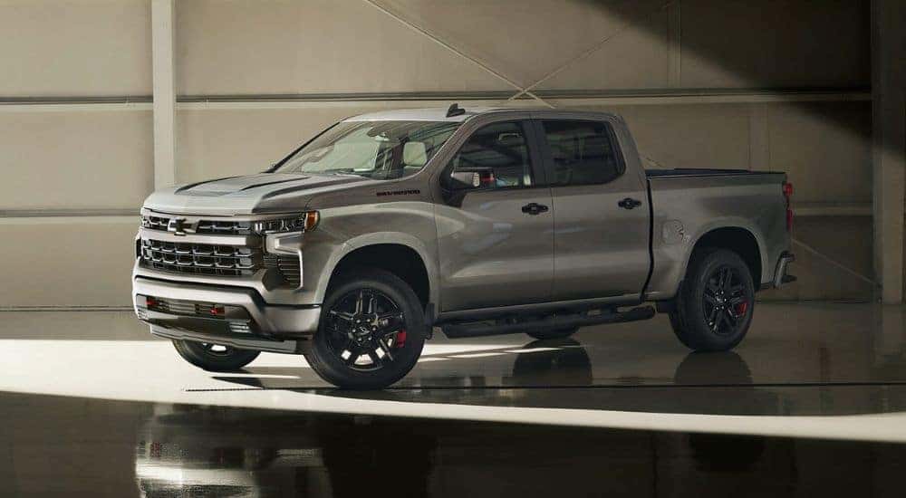 A silver 2024 Chevy Silverado 1500 Redline Edition is shown parked in a garage.