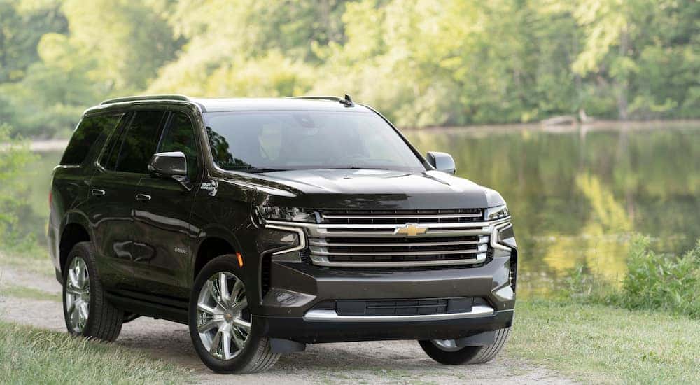 A black 2021 Chevy Tahoe High Country parked next to a lake.