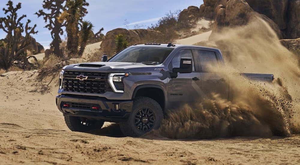 A grey 2024 Chevy Silverado 2500 HD ZR2 driving in a desert.
