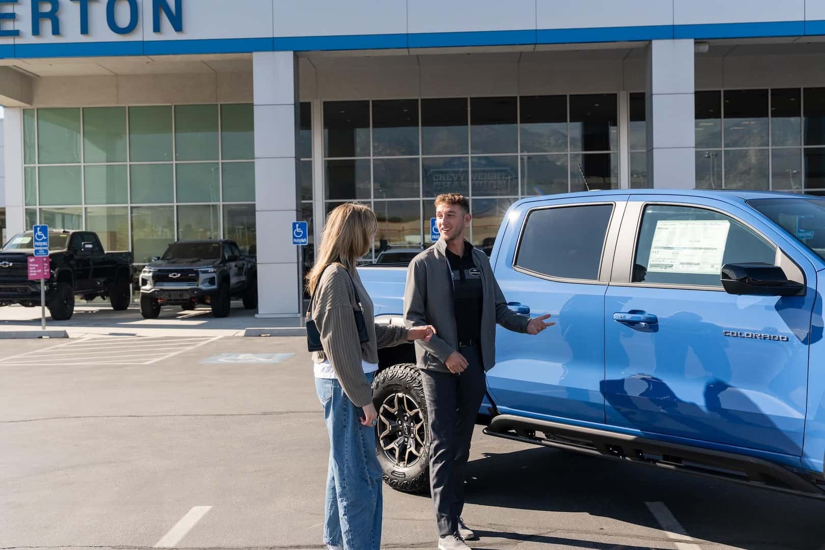 Two people speaking next to Colorado truck
