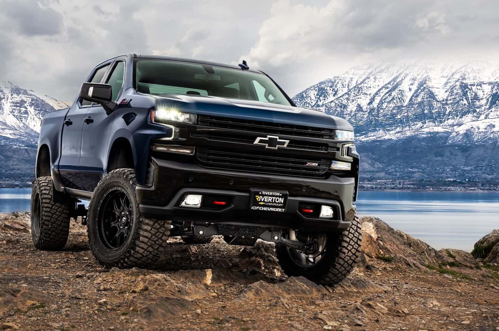 Chevy truck in front of lake and mountains