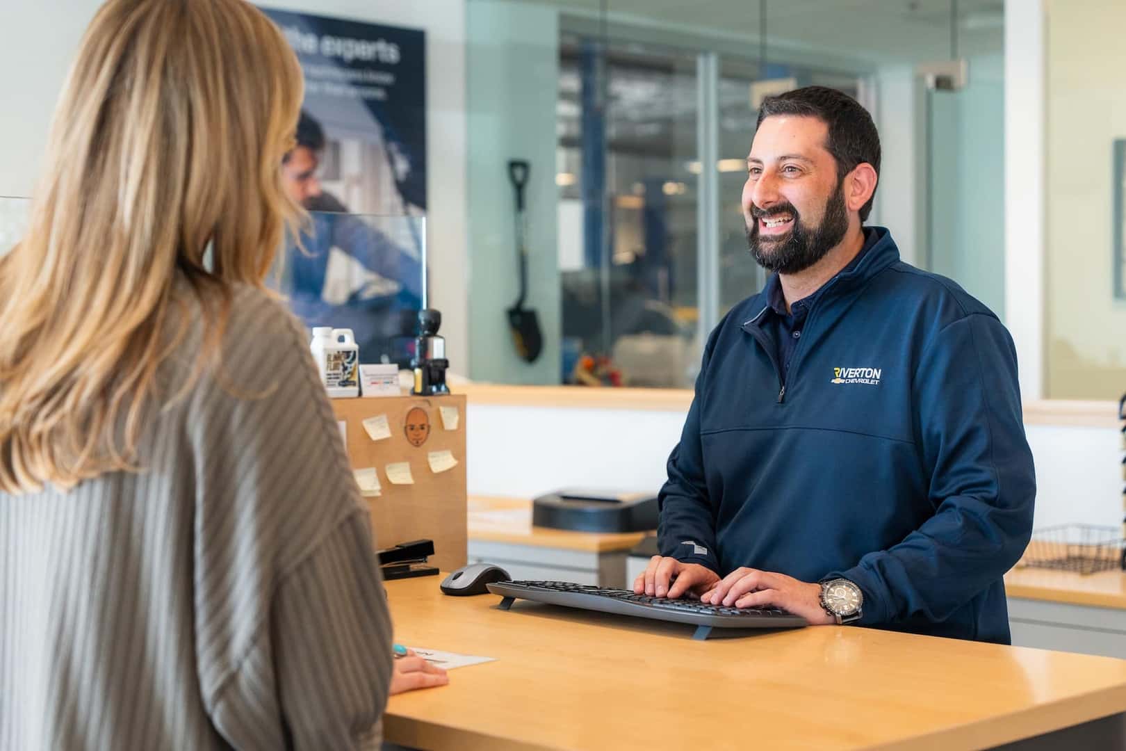 Guy helping a person schedule service at dealership