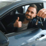 guy siting inside car holding the car keys out the window