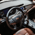 Cadillac interior showing leather seats, steering wheel, and dashboard controls in a luxury vehicle at Riverton Elko