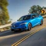 blue acura on road driving