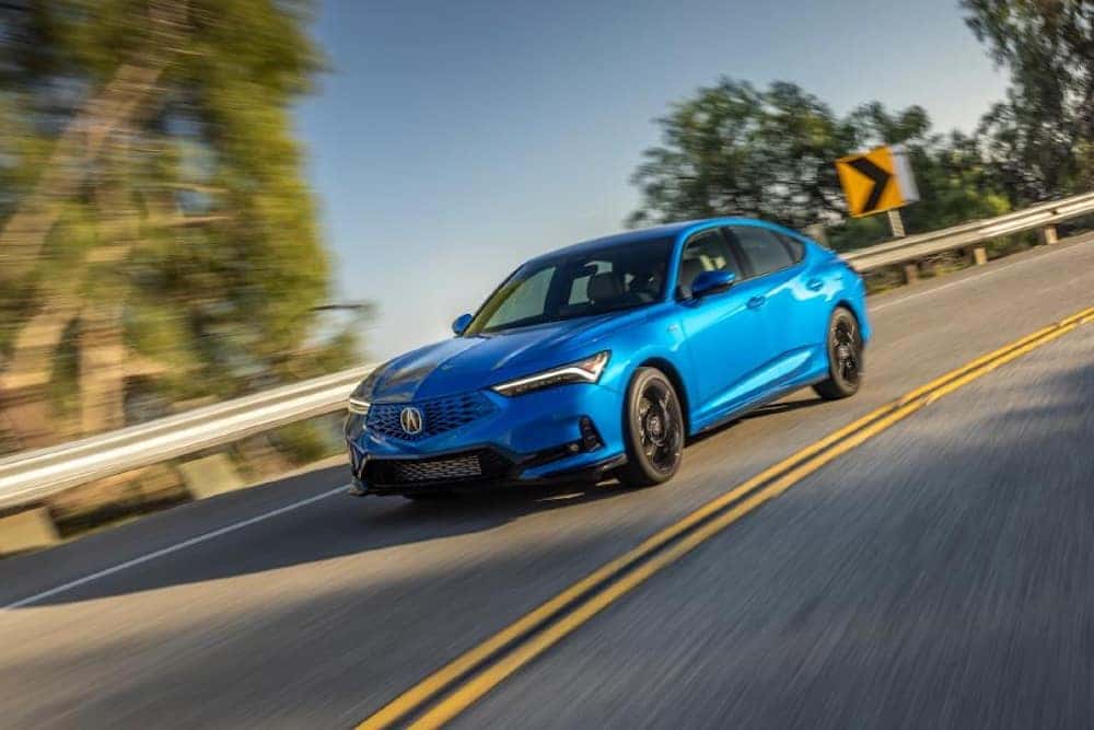 Blue Acura on road driving