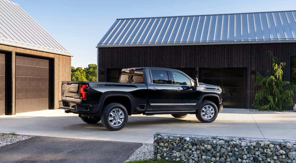 A black 2024 Chevy Silverado 2500 HD High Country is shown from the side.