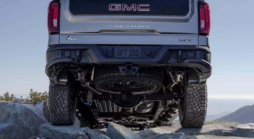 A silver 2023 GMC Sierra 1500 AT4X AEV Edition is shown parked off-road.