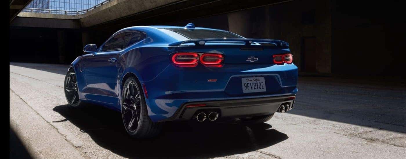 Rear angle view of a parked blue 2024 Chevy Camaro SS.