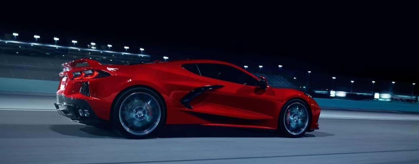 A red 2024 Chevy Corvette Stingray Z51 driving on a track at night.