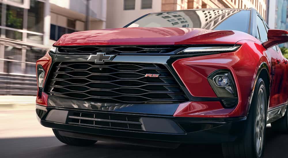 Close-up on the grille and headlights of a red 2025 Chevy Blazer RS.