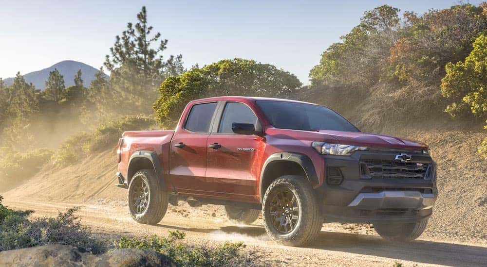 A red 2025 Chevy Colorado Trail Boss is shown from the front at an angle after leaving a Chevy dealer near me.