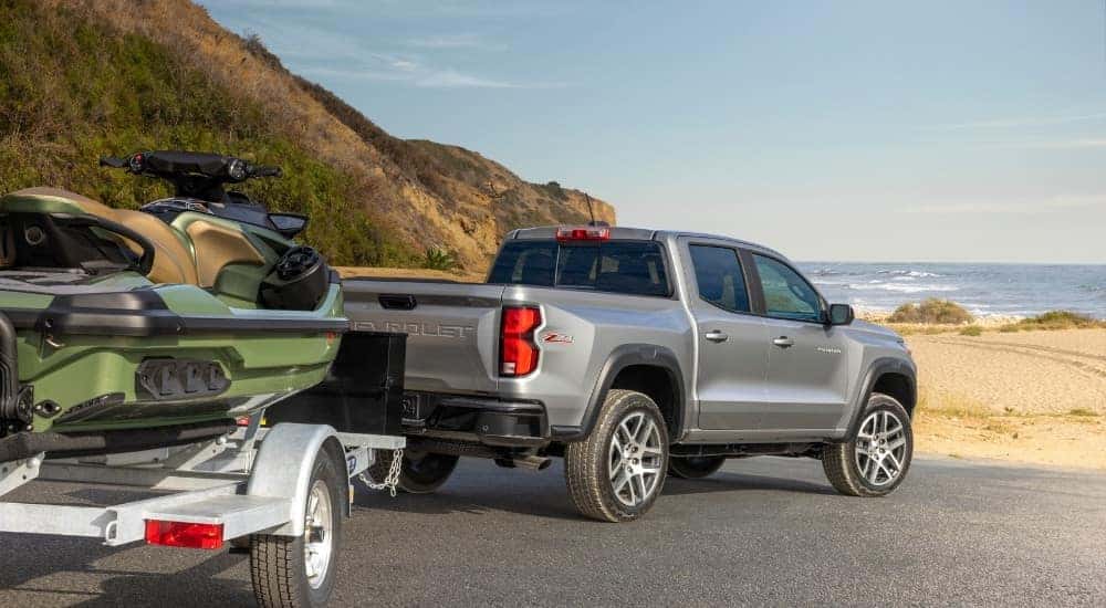 A silver 2025 Chevy Colorado Z71 is shown from the rear while towing a boat.