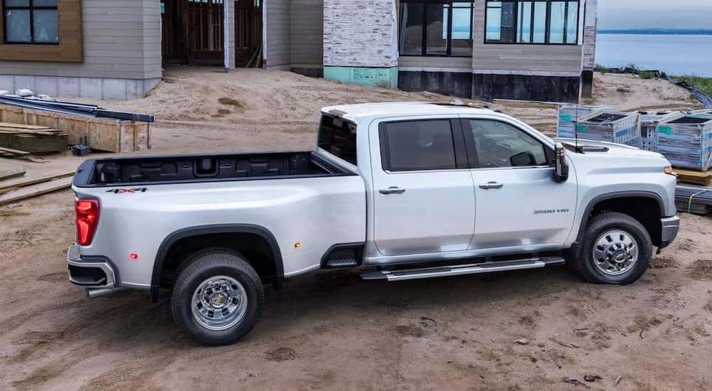 A white 2025 Chevy Silverado 3500 HD is shown parked on a construction site.