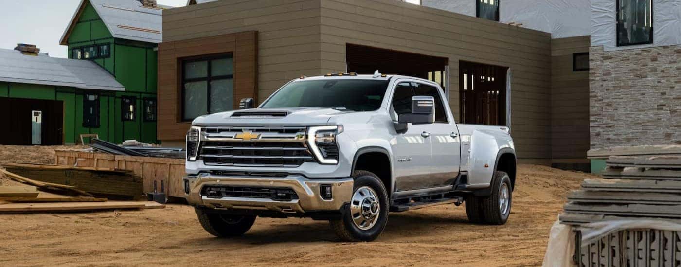 A white 2025 Chevy Silverado 3500 HD is shown parked on a construction site.