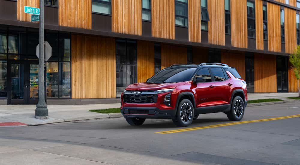 A red 2025 Chevy Equinox RS on a city street.