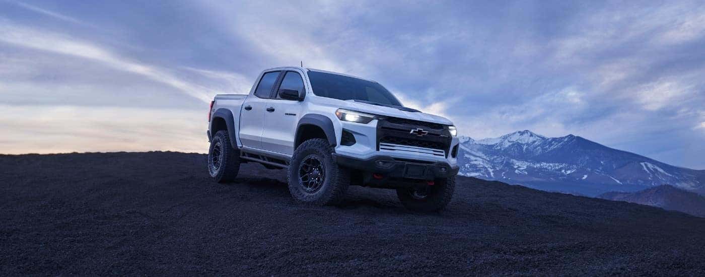 A white 2024 Chevy Colorado driving down a hill.