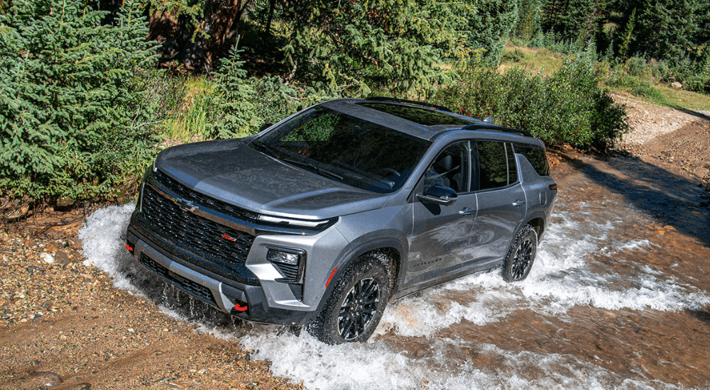 Silver 2026 Chevy Traverse Z71 for sale driving across a creek.