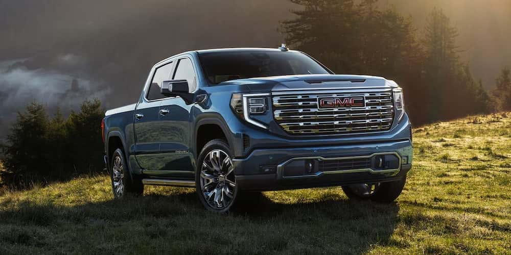 Blue 2026 GMC Sierra 1500 parked on a grassy knoll