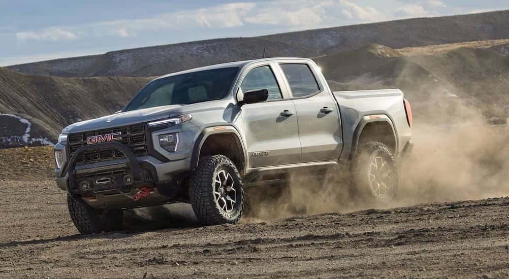 A silver 2026 GMC Canyon AT4X off-roading.