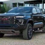 A black 2026 GMC Canyon Denali parked in a driveway.