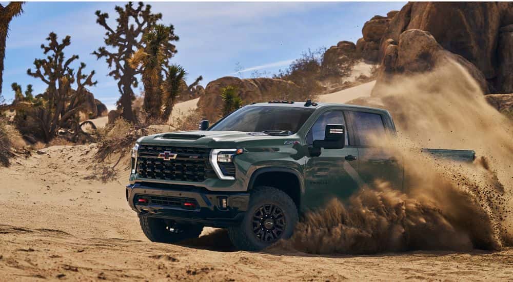 Green 2026 Chevy Silverado 2500 HD off-roading through a desert