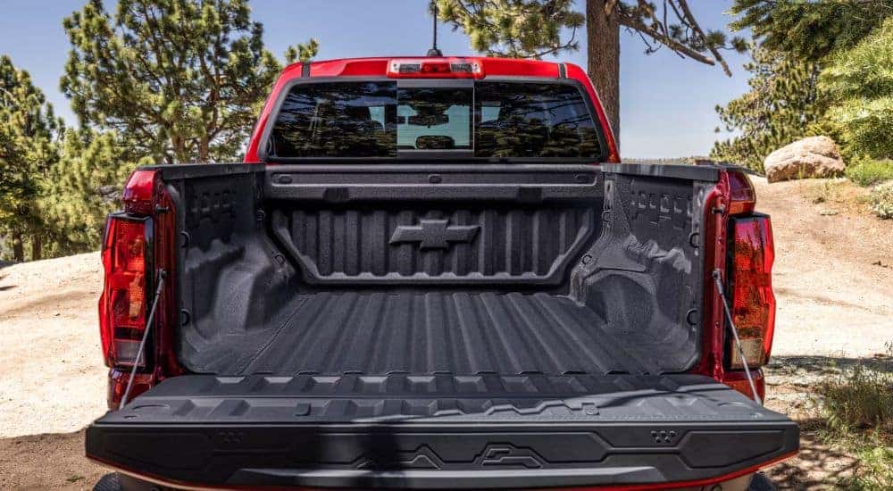 Rear view of a red 2026 Chevy Colorado with rear gate open.